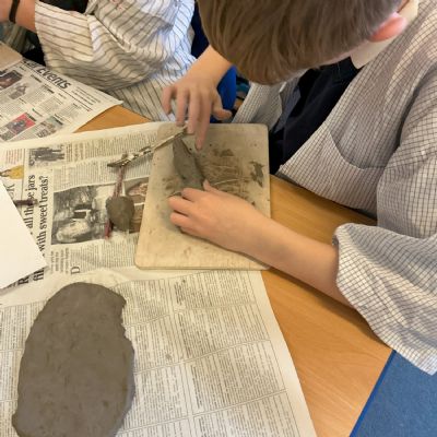 Children making clay lizards